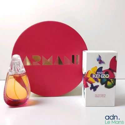 un petit flacon de parfum à côté d'un coffret de parfum