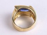 a gold ring with a blue stone in it