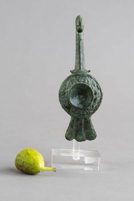 un gros plan sur une figurine avec une poire à côté