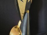 a black and gold sculpture of a woman ' s face on a black background