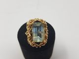 a gold ring with an aquamarinee stone in the center