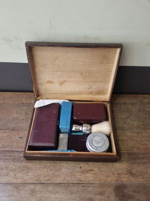 a wooden box with a watch, a book, and other items in it