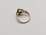 a close up of a gold ring with a black diamond