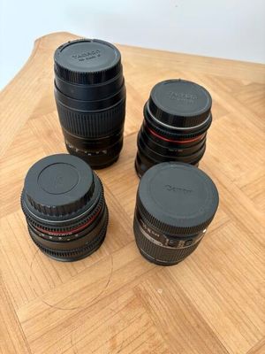 quatre objectifs d'appareil photo posés les uns à côté des autres sur une table en bois