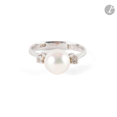 a close up of a pearl and diamond ring on a white background