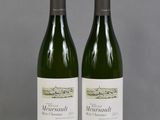 deux bouteilles de vin posées sur une table l'une à côté de l'autre