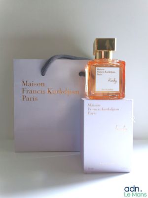perfume bottle in a white box next to a white box with a black ribbon