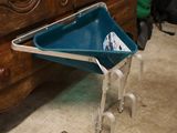 une brouette bleue sur laquelle est posé un bac en plastique