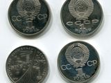 quatre pièces de monnaie provenant de différents pays sont représentées sur un fond blanc