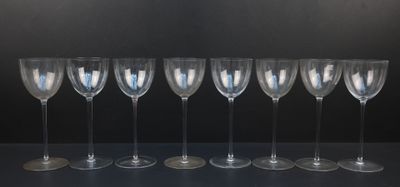 six empty wine glasses lined up in a row against a black background