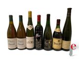 several bottles of wine are lined up in a row on a white surface