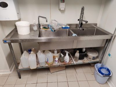 un évier sur lequel sont posés de nombreuses bouteilles et récipients