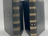 deux livres noirs ornés de bordures dorées, posés côte à côte