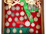 a wooden box filled with silver medals and ribbons