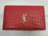 a red saint laurent wallet with a gold y logo on the front