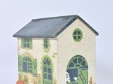 a small toy house on wheels with a dog in the doorway