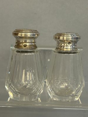 two salt and pepper shakers sitting on a clear tray
