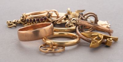 une pile de bagues en or et d'autres bijoux posés sur une table