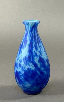 a blue and white vase sitting on a gray surface