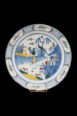 an image of a blue and white plate with a painting on it