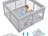 Le bébé joue dans son parc avec des balles et une paire de ciseaux.