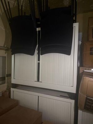 two black shirts hanging on a white cabinet in a kitchen