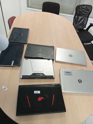 Plusieurs ordinateurs portables sont posés sur une table ronde dans un bureau