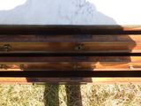 un banc en bois posé dans l'herbe, avec une montagne en arrière-plan