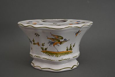 un vase blanc orné d'un dragon, posé sur un fond gris