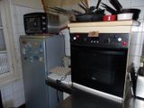 une cuisine équipée d'une cuisinière, d'un micro-ondes et d'un réfrigérateur