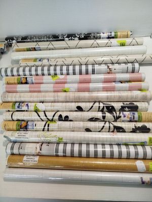 plusieurs rouleaux de papier d'emballage posés sur une étagère à côté d'une paire de ciseaux