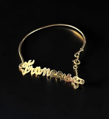 un bracelet en or avec le mot « person » gravé dessus