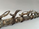a close up of a long metal object with horns on it