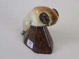 a figurine of a dog sitting on a rock