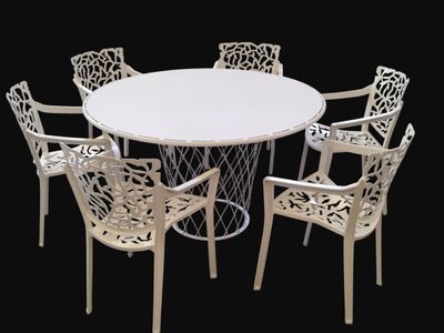 a white table with four chairs around it on a black background
