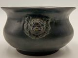 a black bowl with a lion head on it