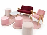 Plusieurs chaises et tabourets de différentes couleurs sont disposés autour d'une table basse