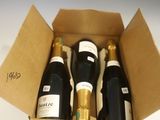 six bouteilles de vin dans un carton sur une table