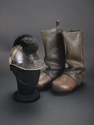 une paire de bottes en cuir et un chapeau en cuir posés sur une surface noire