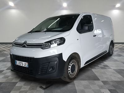 une camionnette blanche garée sur un sol en damier