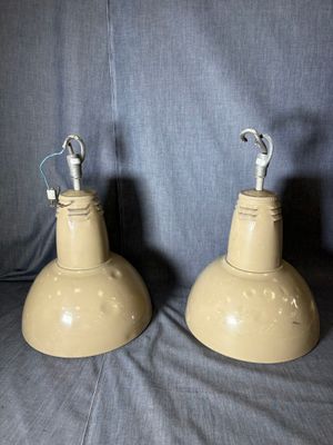 une paire de lampes industrielles jaunes sur fond bleu