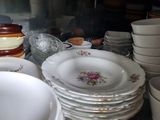 many plates and bowls on the counter in the kitchen