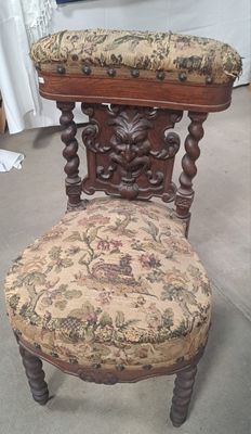 une chaise en bois sur laquelle est posé un coussin recouvert d'un tissu à motifs floraux