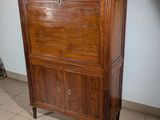 a wooden cabinet with a marble top on a tiled floor