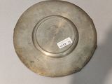 a silver plate with a tag on it on a table
