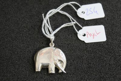 un pendentif en forme d'éléphant en argent auquel est attachée une étiquette de prix