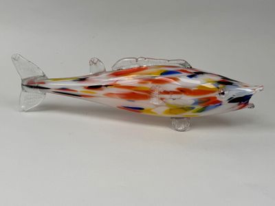 un poisson en verre posé sur une surface blanche