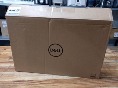 a dell laptop sitting on a wooden table in a room