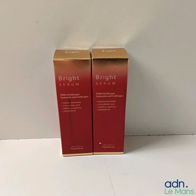 Deux boîtes de sérum aux couleurs vives sont posées sur une surface blanche