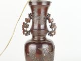 un vase marron avec une anse dorée sur fond blanc